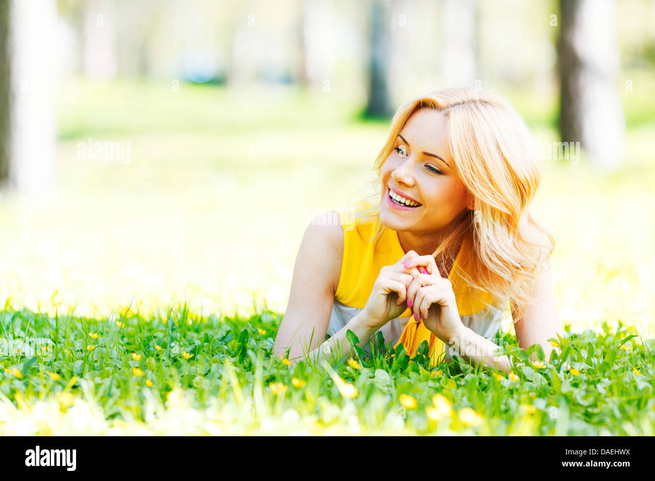 Happy young woman lying on grass Stock Photo - Alamy