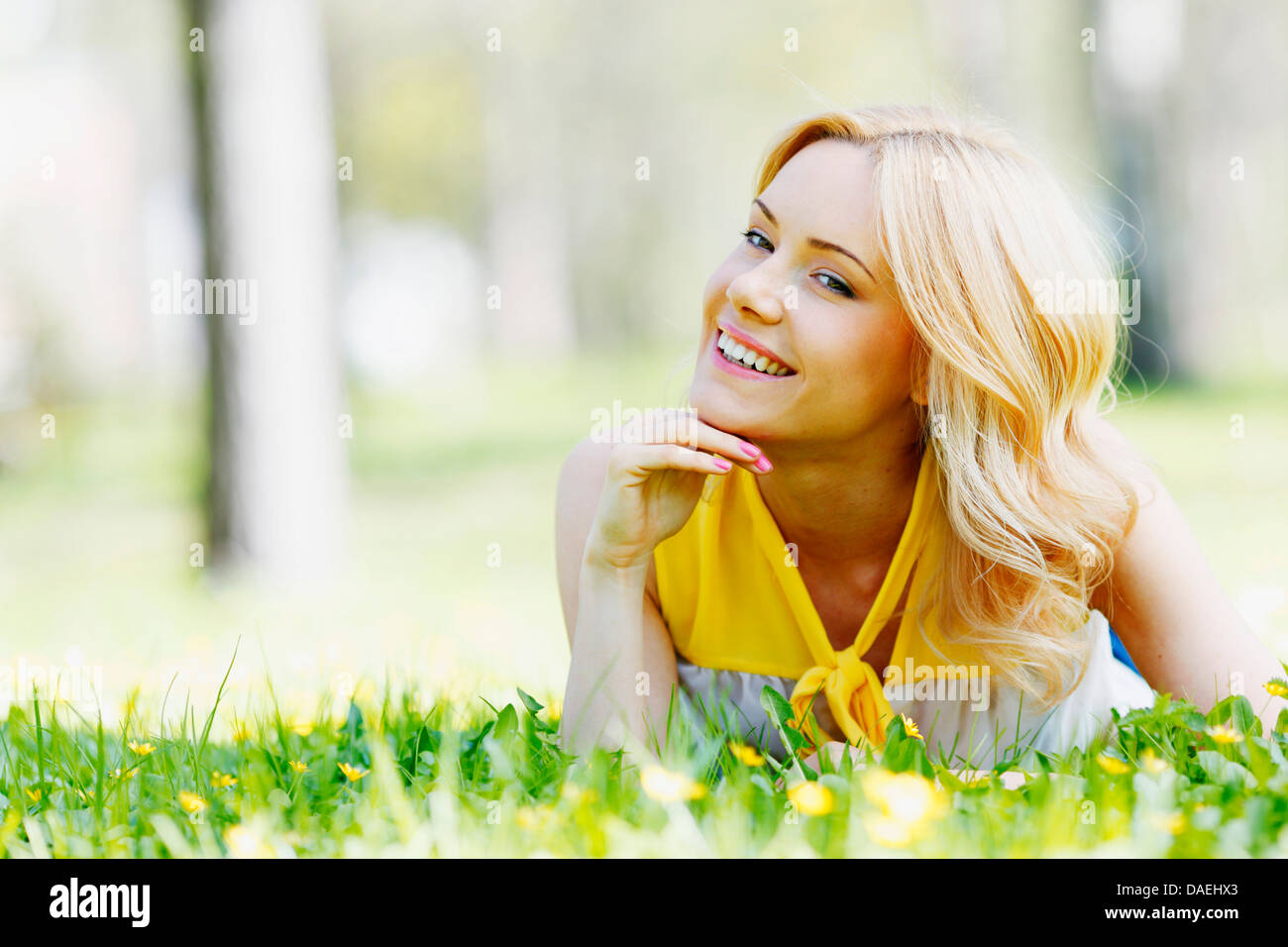 Happy young woman lying on grass Stock Photo - Alamy