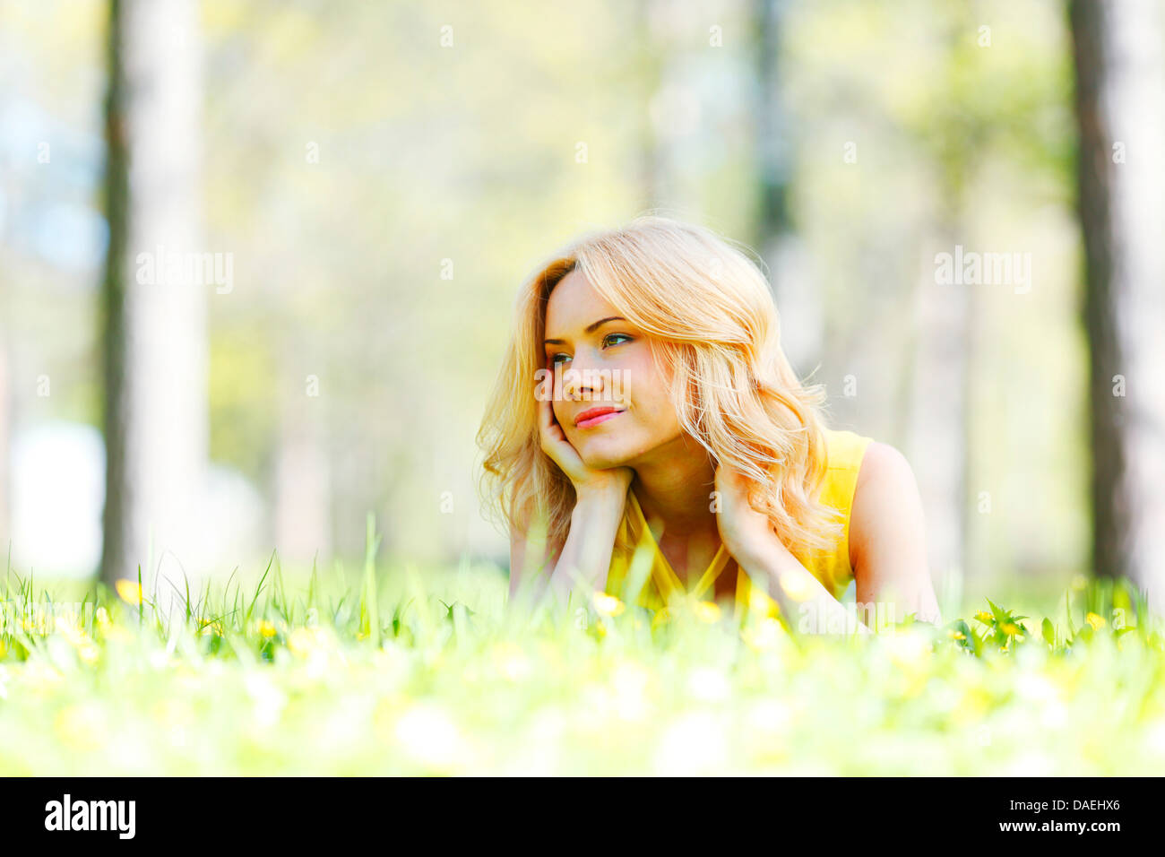 Happy young woman lying on grass Stock Photo - Alamy