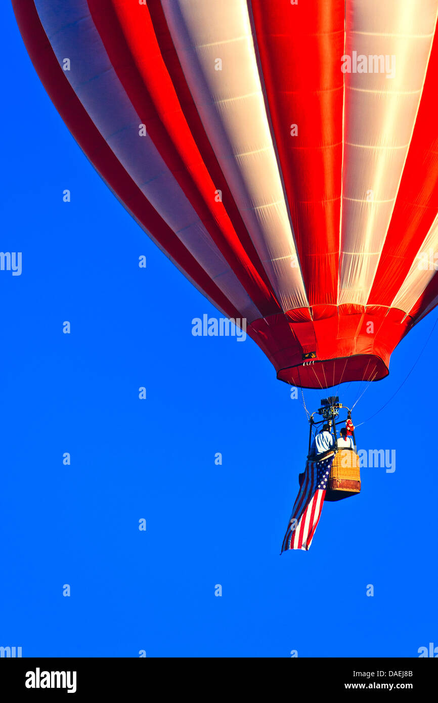 Closeup on red and white hot air balloon flying American flag against blue sky at Spirit of Boise Balloon Classic in 2011 Stock Photo