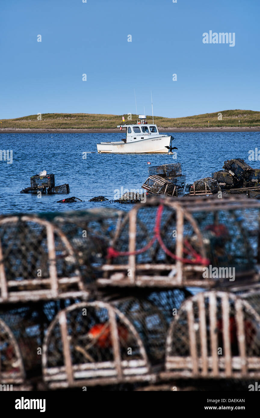 Wooden lobster traps and boat in Nauset Harbor, Orleans, Cape Cod, Massachusetts, USA Stock Photo