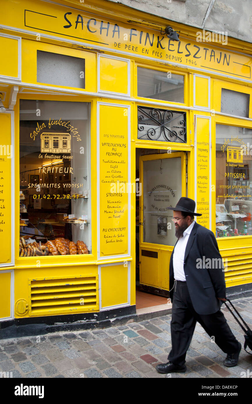 Orthodox Jew walks past historic Yiddish bakery Finkelsztajn in the