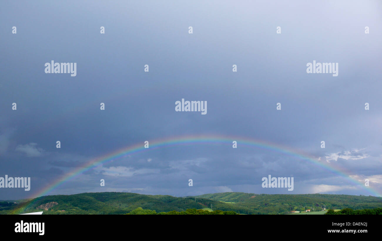 rainbow over forested hill landscape, Germany, North Rhine-Westphalia, Ruhr Area, Witten Stock Photo