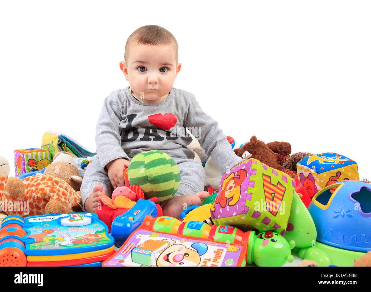 baby sitting in a heap of playthings Stock Photo