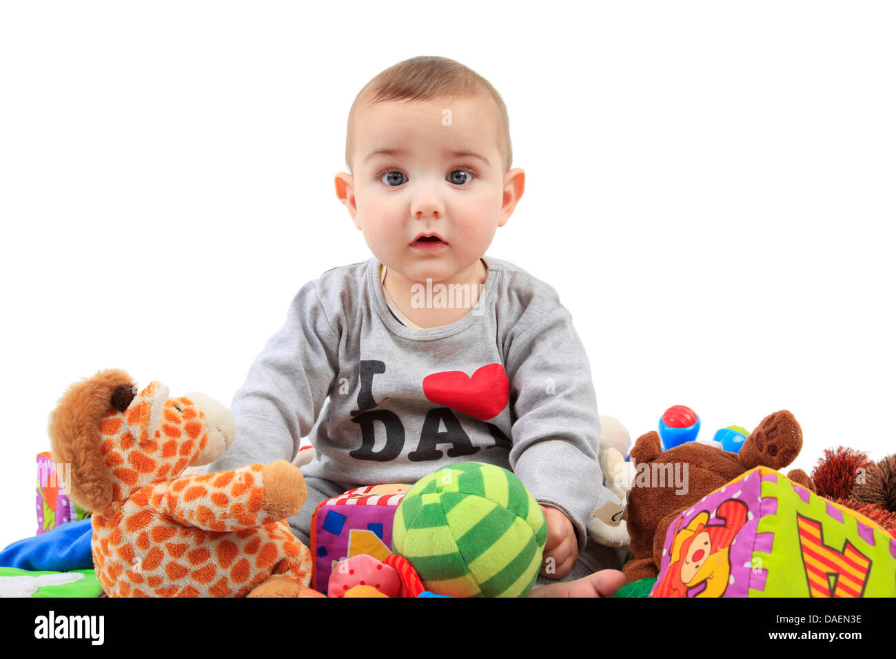 baby sitting in a heap of playthings Stock Photo