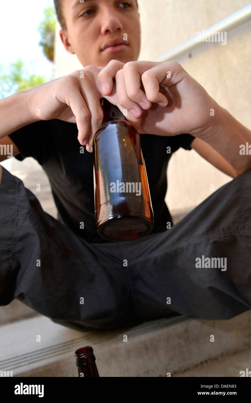 An 18-year-old male with a beer bottle. Stock Photo