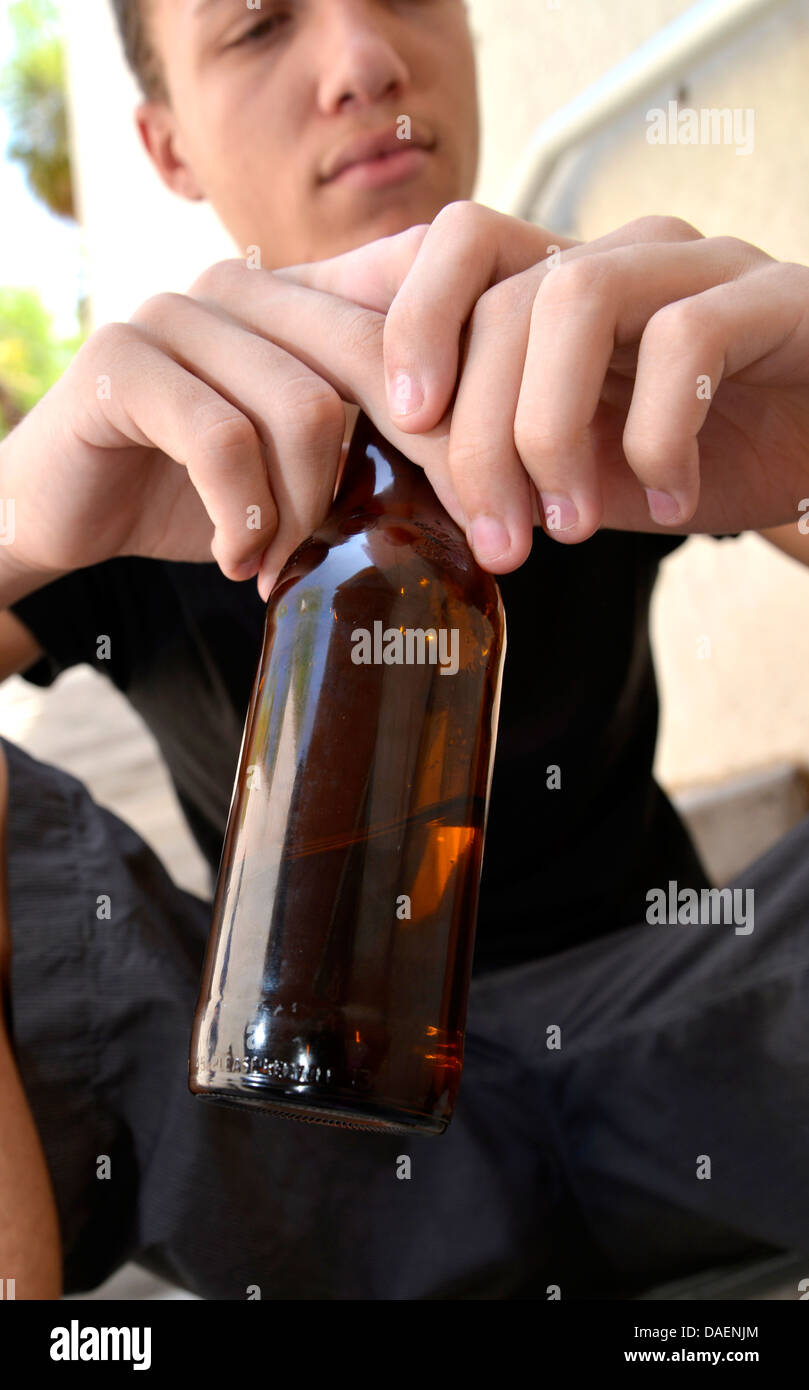An 18-year-old male with a beer bottle. Stock Photo