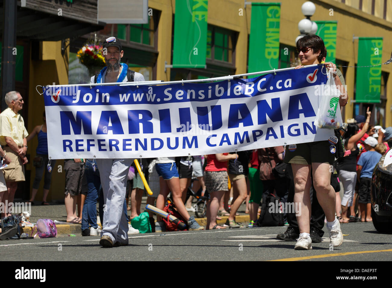 Man and woman carrying pro marijuana slogan sign during Gay Pride parade-Victoria, British Columbia, Canada Stock Photo