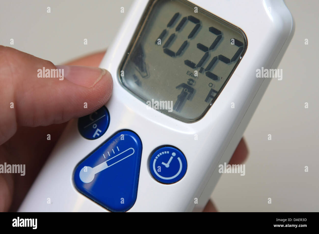 hand holding a digital thermometer reading fever, hyperthermia Stock Photo