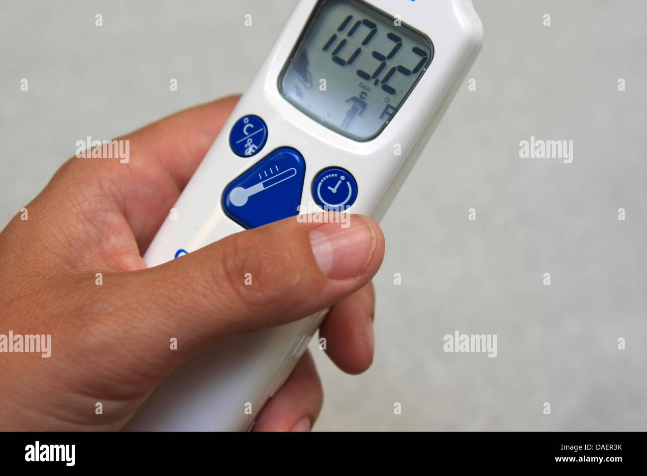 hand holding a digital thermometer reading fever, hyperthermia Stock Photo