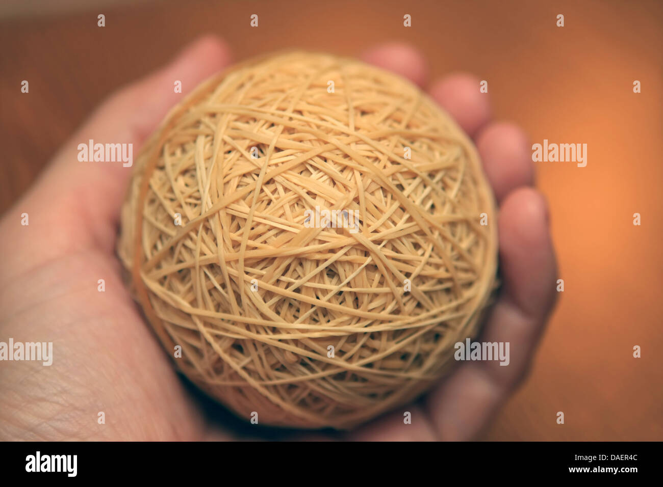 rubber band ball held in left hand Stock Photo