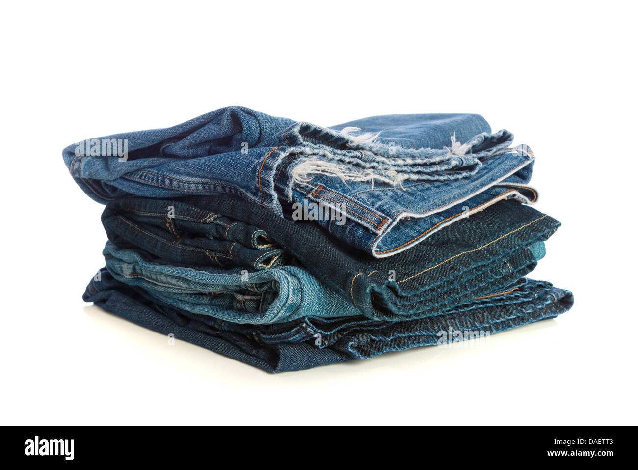Stack of old blue jeans on a white background Stock Photo