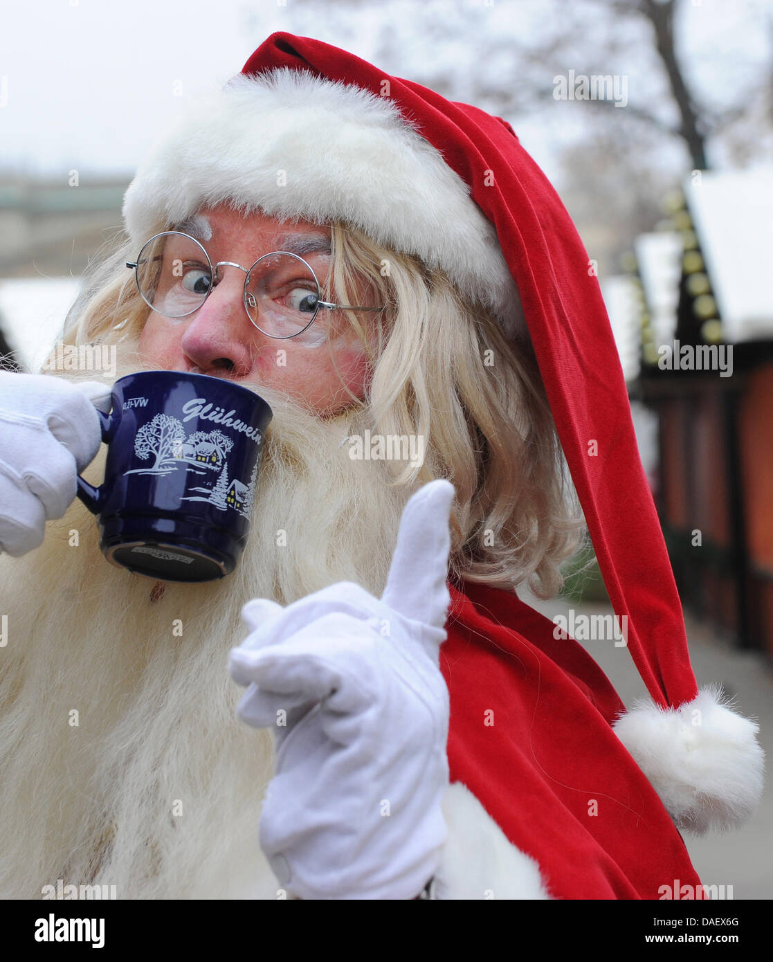 A man dressed up as Santa Clause drinks a cup of mulled wine at the nostalgic Christmas market at the Opera palace in Berlin, Germany, 17 November 2011. From 23 November 2011 till 26 December 2011 the Christmas market, which celebrates its 20th anniversary, will be home to 160 booths and rides. Photo: JENS KALAENE Stock Photo