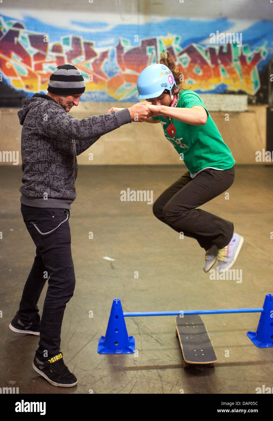 Germany's skateboard pionier Eberhard "Titus" Dittmann (L) practices a  trick with trainee teacher Lilly Uebele in his "Skater's Palace" in  Muenster, Germany, 22 November 2011. Dittmann brought the sport fad  skateboarding to