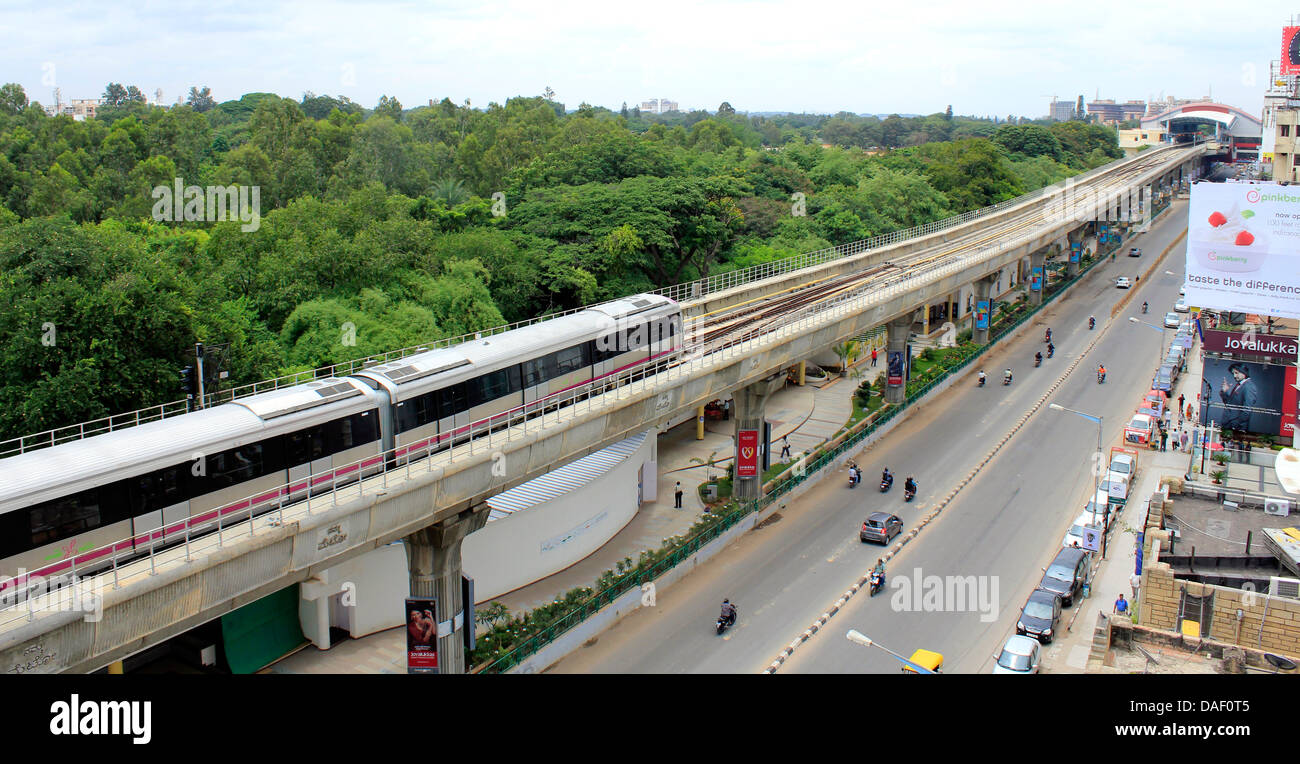 Bangalore city. Among greenery, a metro train nears the M G Road station. Stock Photo