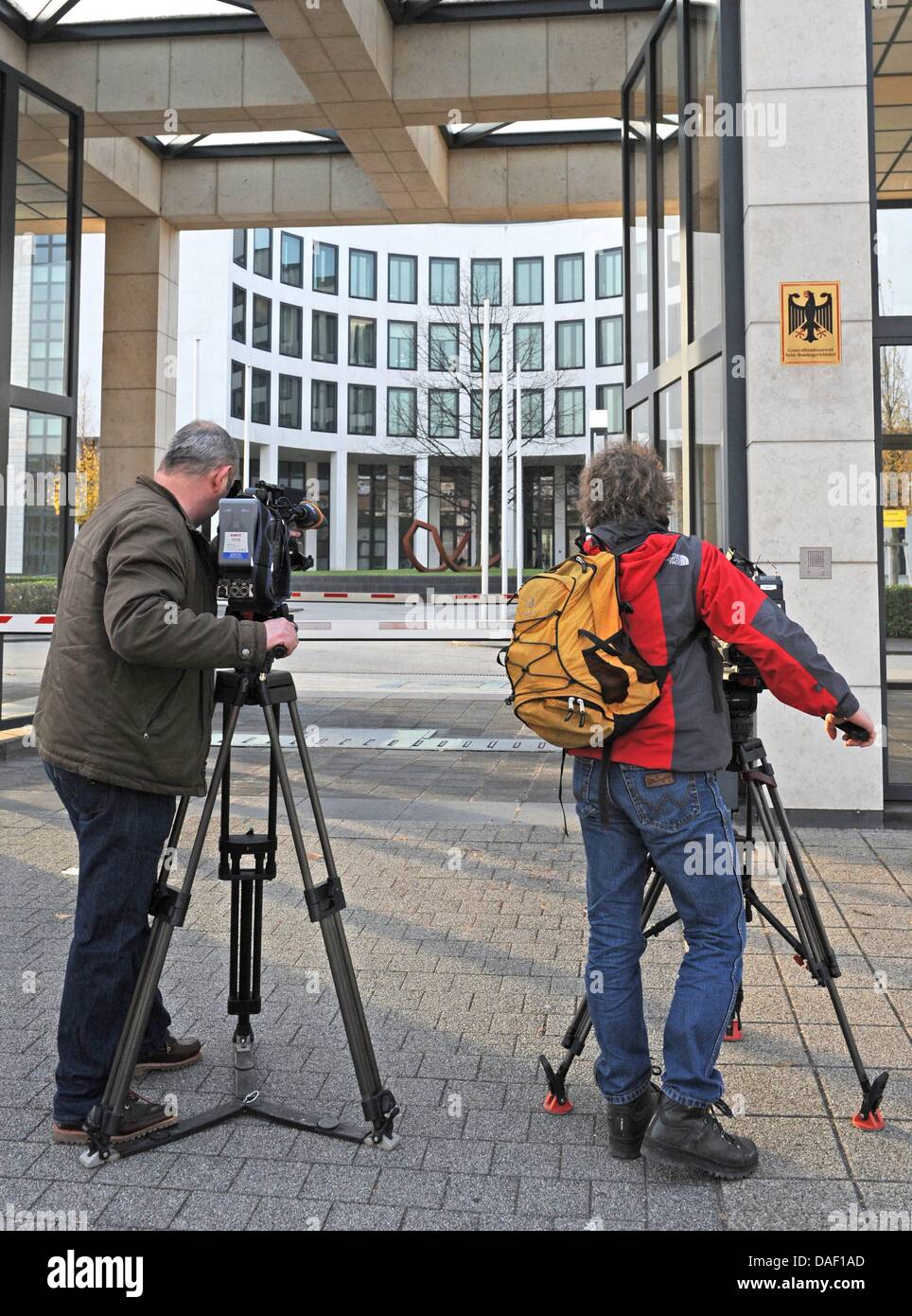 Two cameramen stand outside of the German Federal Public Prosecutor in Karlsruhe, Germany, 24 November 2011. Andre E. is being brought to Karlsruhe for a detention hearing at the Federal Court. He is accused in two cases of supporting the right-wing radical, terrorist association NSU ('National Socialist Underground'). Special operations unit from GSG 9 arrested the 32 year old And Stock Photo