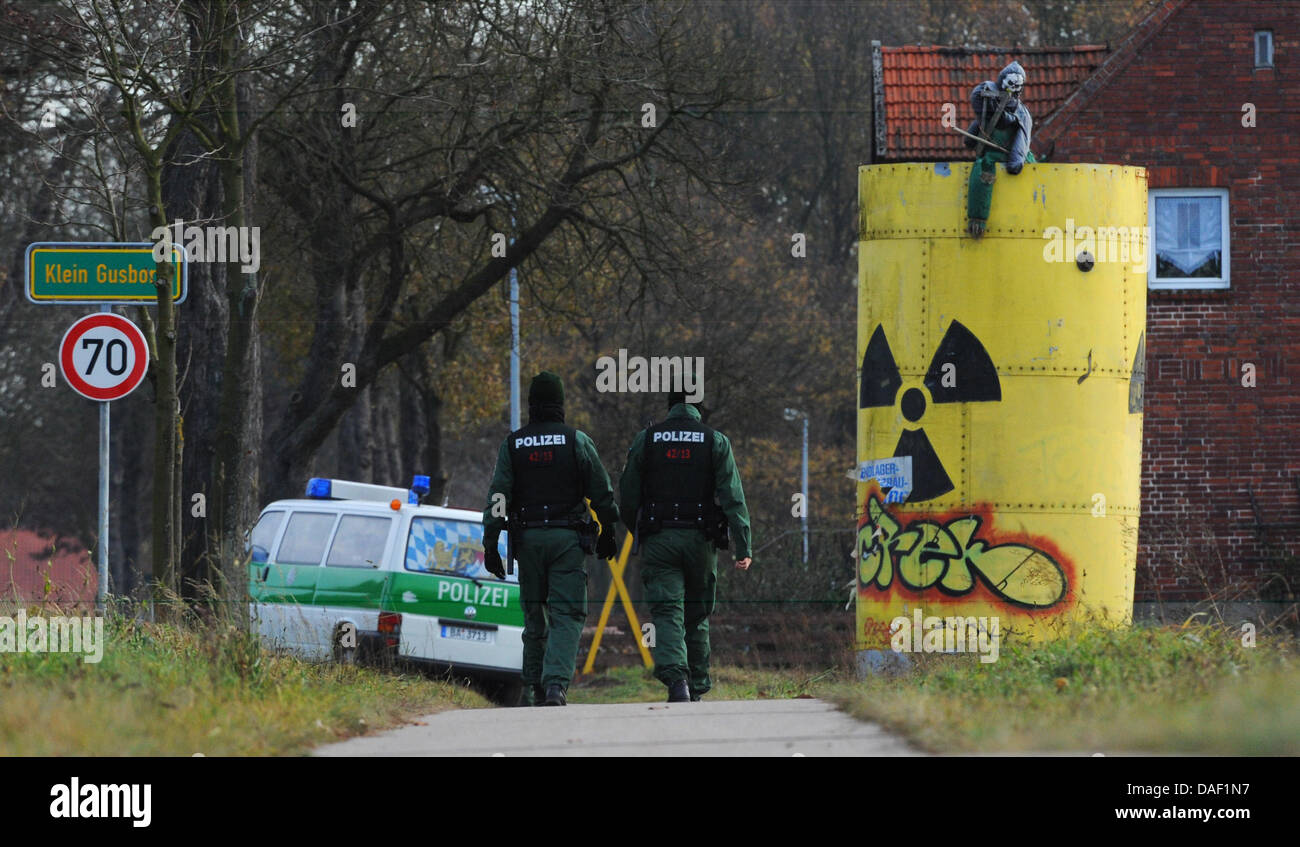 Police walk past a large nuclear waste container near Klein Gusborn, Germany, 25 November 2011. The 13th CASTOR transport with German nuclear waste is expected in Wendland from the reprocessing plant in France on the coming weekend. Photo: 25 November 2011. Photo: JULIAN STRATENSCHULTE Stock Photo