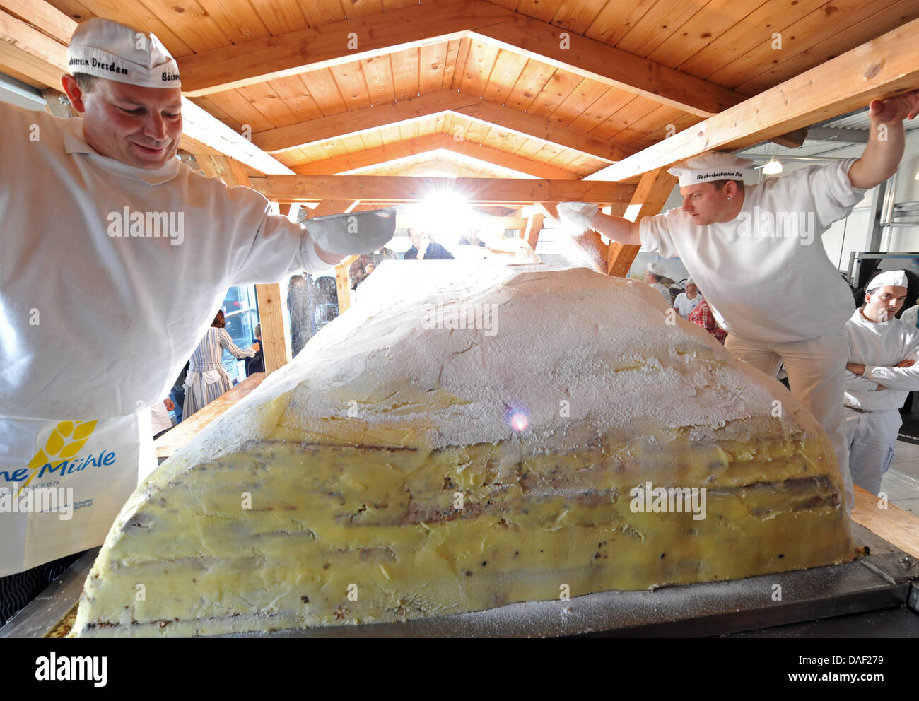 The bakers of the protective association Dresden Stollen put sugar on a giant stollen in Dresden, Germany, 27 November 2011. The traditional Christmas cake is prepared for the 18th Dresden Stollen Festival on 03 December 2011. Photo: MATTHIAS HIEKEL Stock Photo