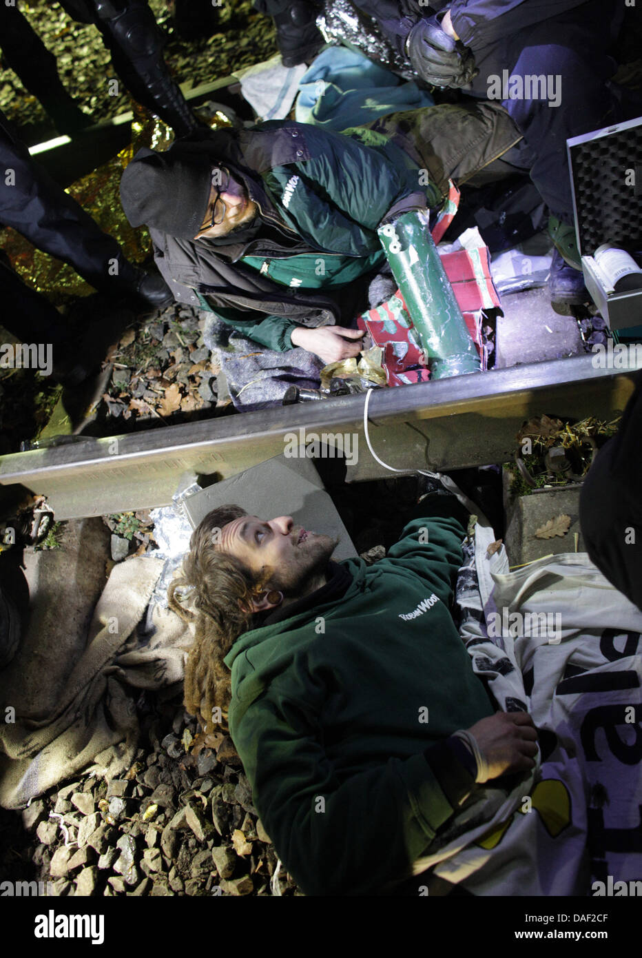 Activist of the environmental group Robin Wood lie chained to the railtracks as police officers try to separate them during the protests against the Castor nuclear transport near Harlingen, Germany, 27 November 2011. The 13th Castor transport with German nuclear waste is expected at the interim storage facility in Gorleben from the reprocessing plant in France this weekend. Photo: Stock Photo