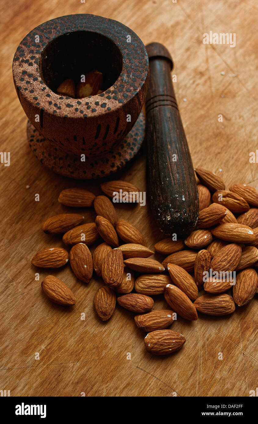 Almond nuts and a ponder on a wooden desk Stock Photo