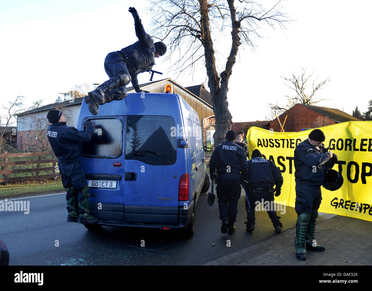 Police officers try  to break open a truck which Greanpeace activists tied to the street in Klein Gusborn, Germany, 28 November 2011. Greenpeace tries to block the entrance way of the interim storage facility. The 13th Castor transport with German nuclear waste is on its way to the interim storage facility in Gorleben from the reprocessing plant in France. Photo: Julian Stratenschu Stock Photo
