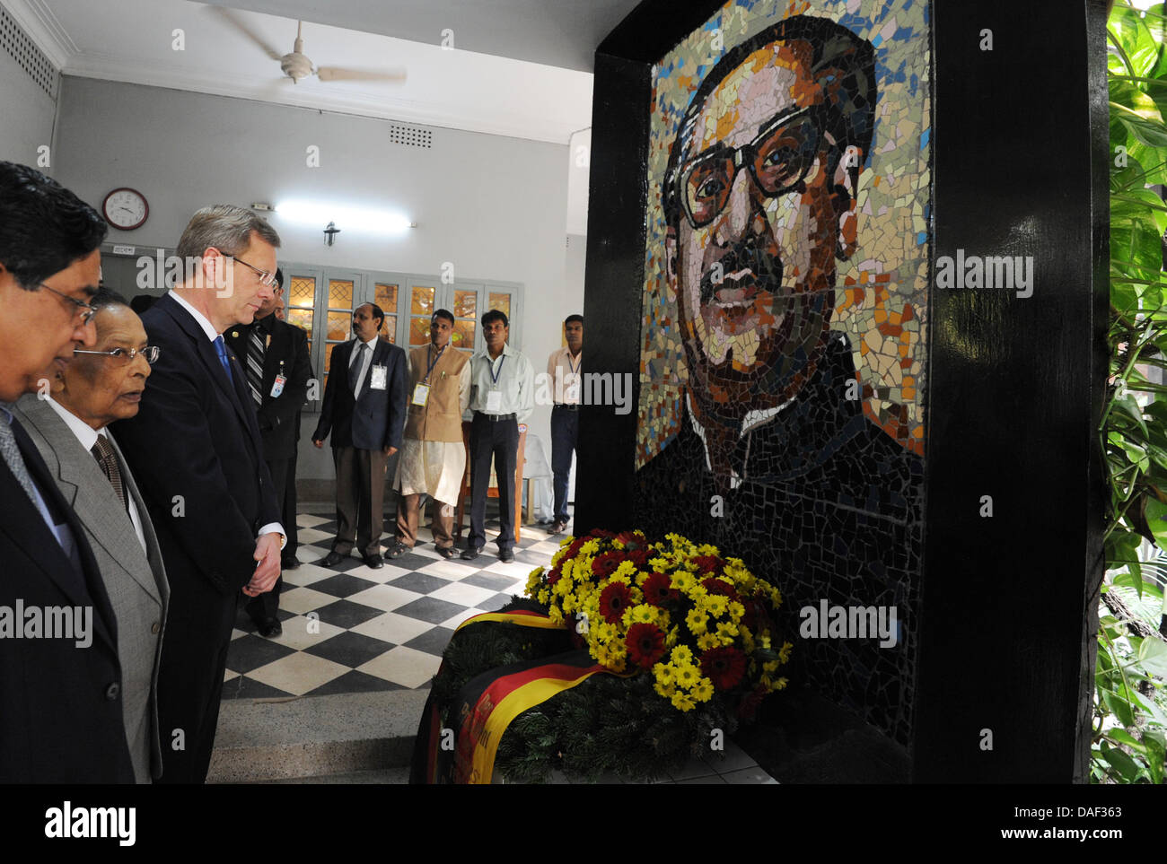 Bundespräsident Christian Wulff (3.v.l.) hält am Dienstag (29.11.2011) bei einer Kranzniederlegung am Bangabandhu-Museum in Dhaka (Bangladesch) einen Augenbilck inne. Die Person auf dem Gemälde ist der Anführer der Unabhängigkeitsbewegung und erster Staatpräsident Bangladeschs. Er wurde 1975 bei einem Attentat in seinem Haus, das heute als Museum dient, getötet. Der Bundespräsident Stock Photo