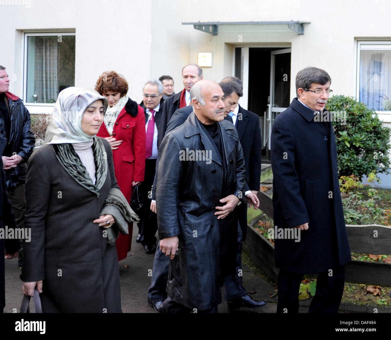 The Turkish Foreign Minister Ahmet Davutoglu (R) and Ali Taskopru (C), father of a vegetable seller murdered in 2001, walk past the victim's house in Hamburg, Germany, 01 December 2011. During his trip through Germany, Davutoglu visits several family members of victims of the Zwickau-based neo-Nazi terror cell. In his four-day-trip, Davutoglu will also visit Wiesbaden, Frankfurt, F Stock Photo