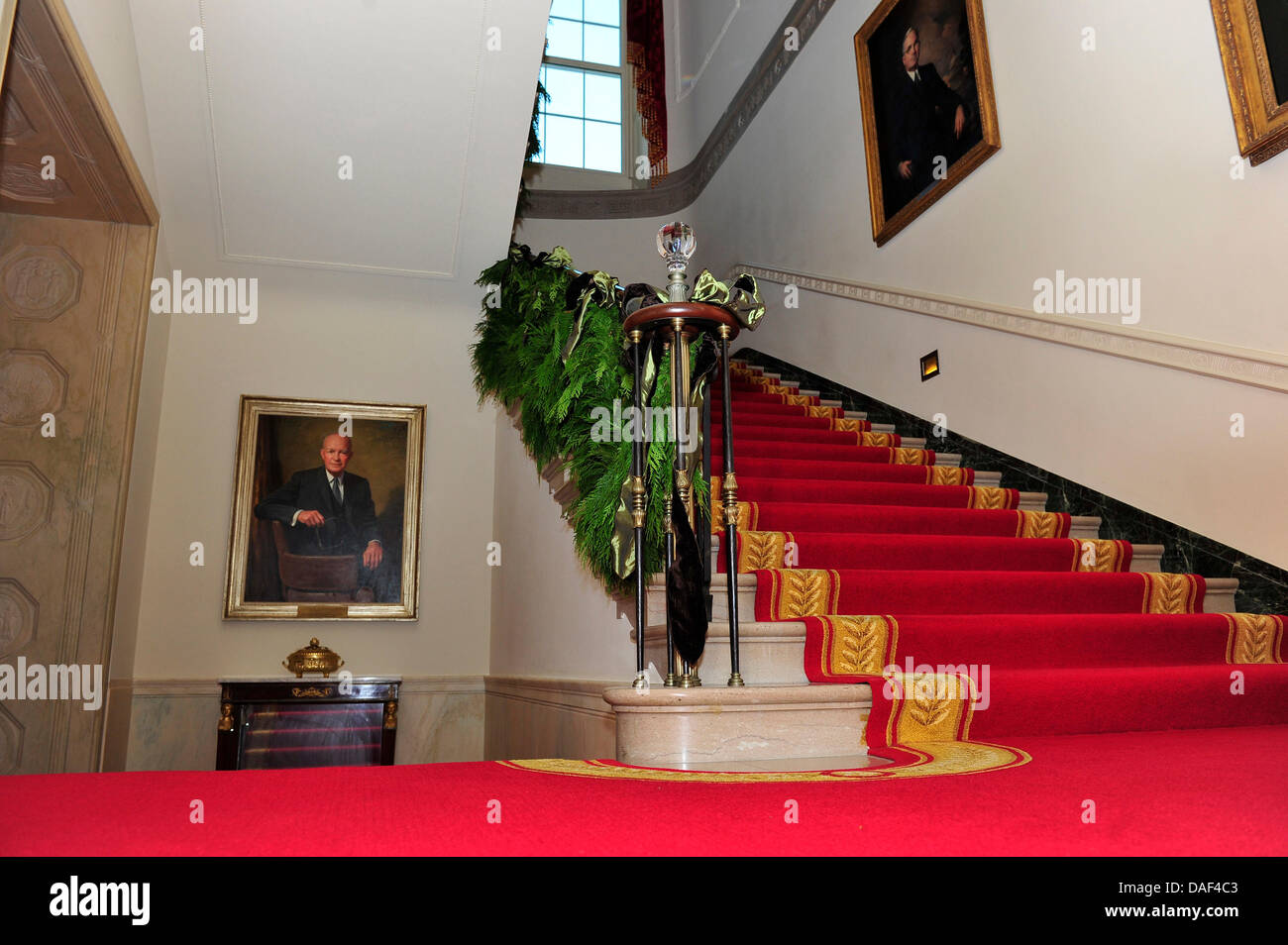 Christmas decorations on the Grand Staircase of the White House in Washington, DC. The official portraits of former United States President Dwight D. Eisenhower is at left and of former U.S. President Harry S Truman is at right. The theme for the White House Christmas 2011 is Shine, Give, Share - celebrating the countless ways we can lift up those around us, put our best self forwa Stock Photo