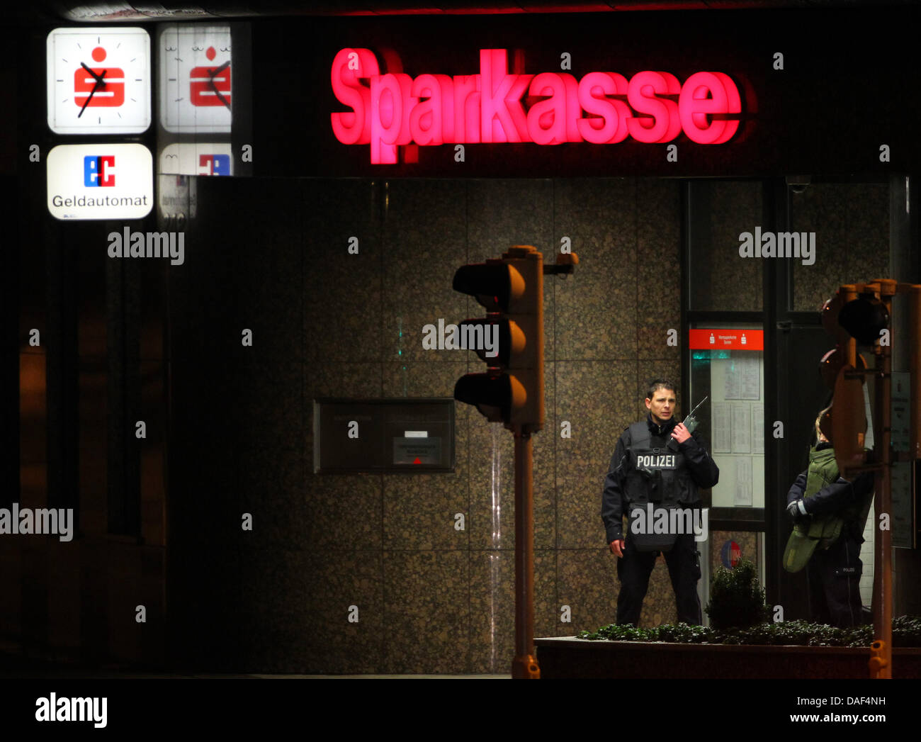 Zwei Polizisten stehen am Donnerstagabend (01.12.2011) vor einer Sparkassenfiliale in Solingen. Die Polizei konnte zwei Frauen aus einem verschlossenen Tresorraum befreien.  Foto: Roland Weihrauch dpa/lnw Stock Photo