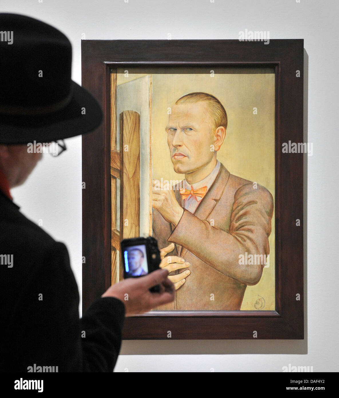 A man photographs a self portrait by Otto Dix in the Orangerie in Gera, Germany, 02 December 2011. The Kunstsammlung will open a retrospective of the painter and graphic artist for his 120th birthday in the evening with around 200 works. The opening is part of the celebratory weekend in honour of the expressionist painter. Photo: HENDRIK SCHMIDT Stock Photo
