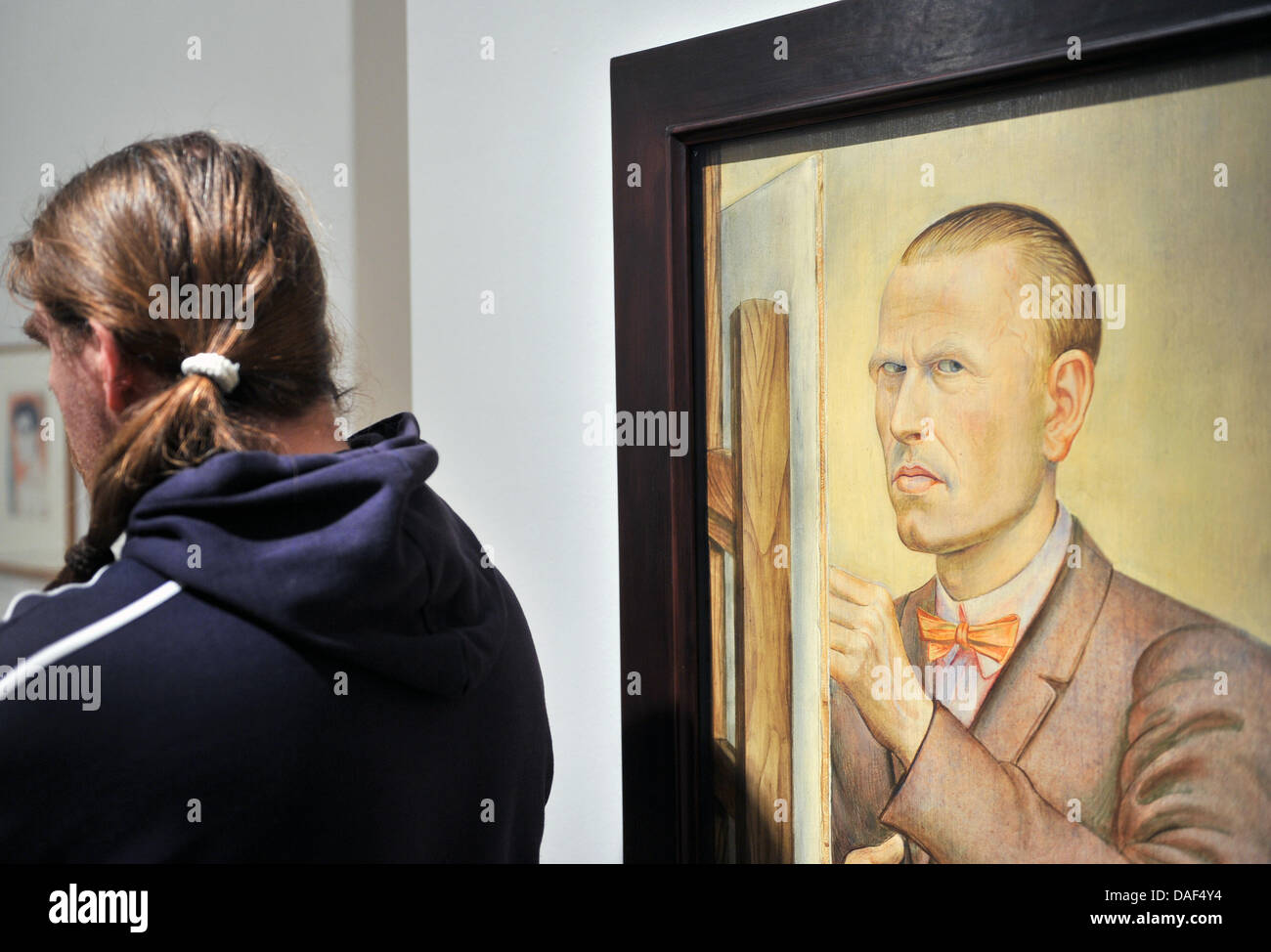 A man stands next to a self portrait by Otto Dix in the Orangerie in Gera, Germany, 02 December 2011. The Kunstsammlung will open a retrospective of the painter and graphic artist for his 120th birthday in the evening with around 200 works. The opening is part of the celebratory weekend in honour of the expressionist painter. Photo: HENDRIK SCHMIDT Stock Photo
