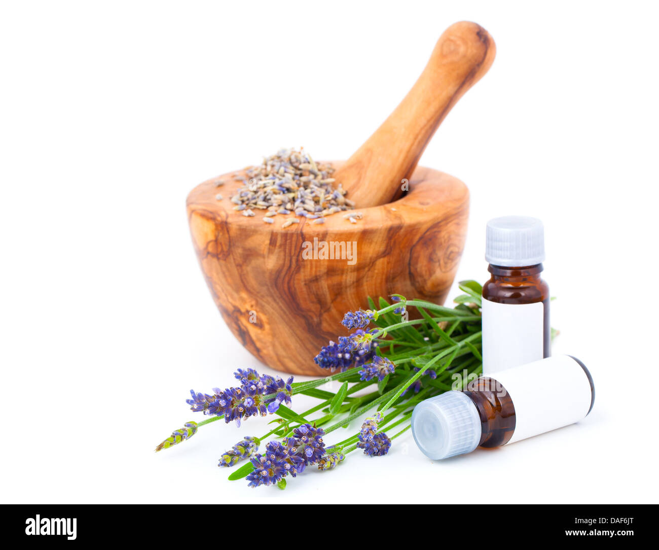 Lavender oil in a wooden bowl, over a white background. Stock Photo