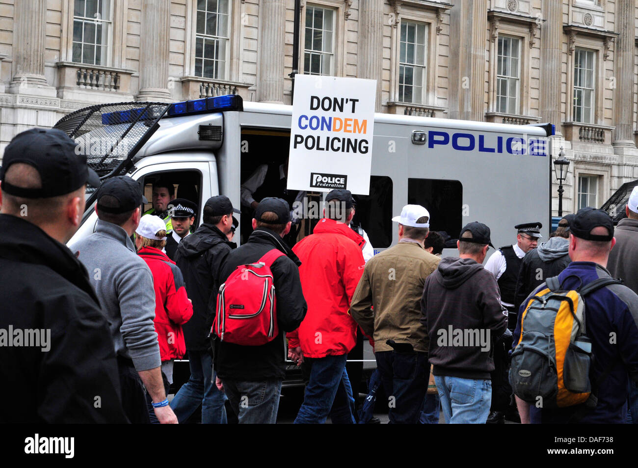Off-duty police officers walk past a police van in Whitehall, London, UK Stock Photo