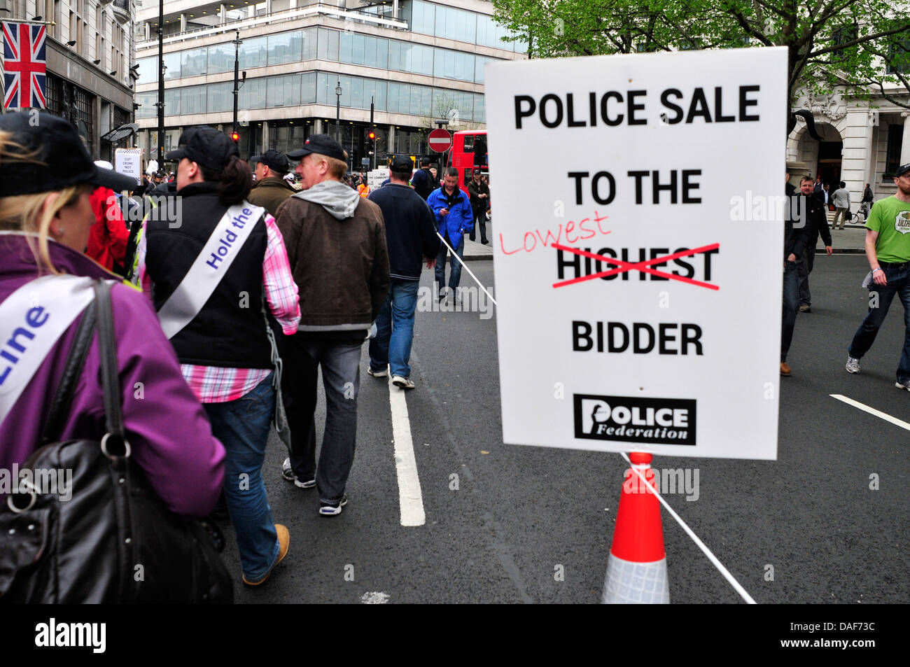 A banner reading 'police sale to the lowest bidder', central London, UK. Stock Photo