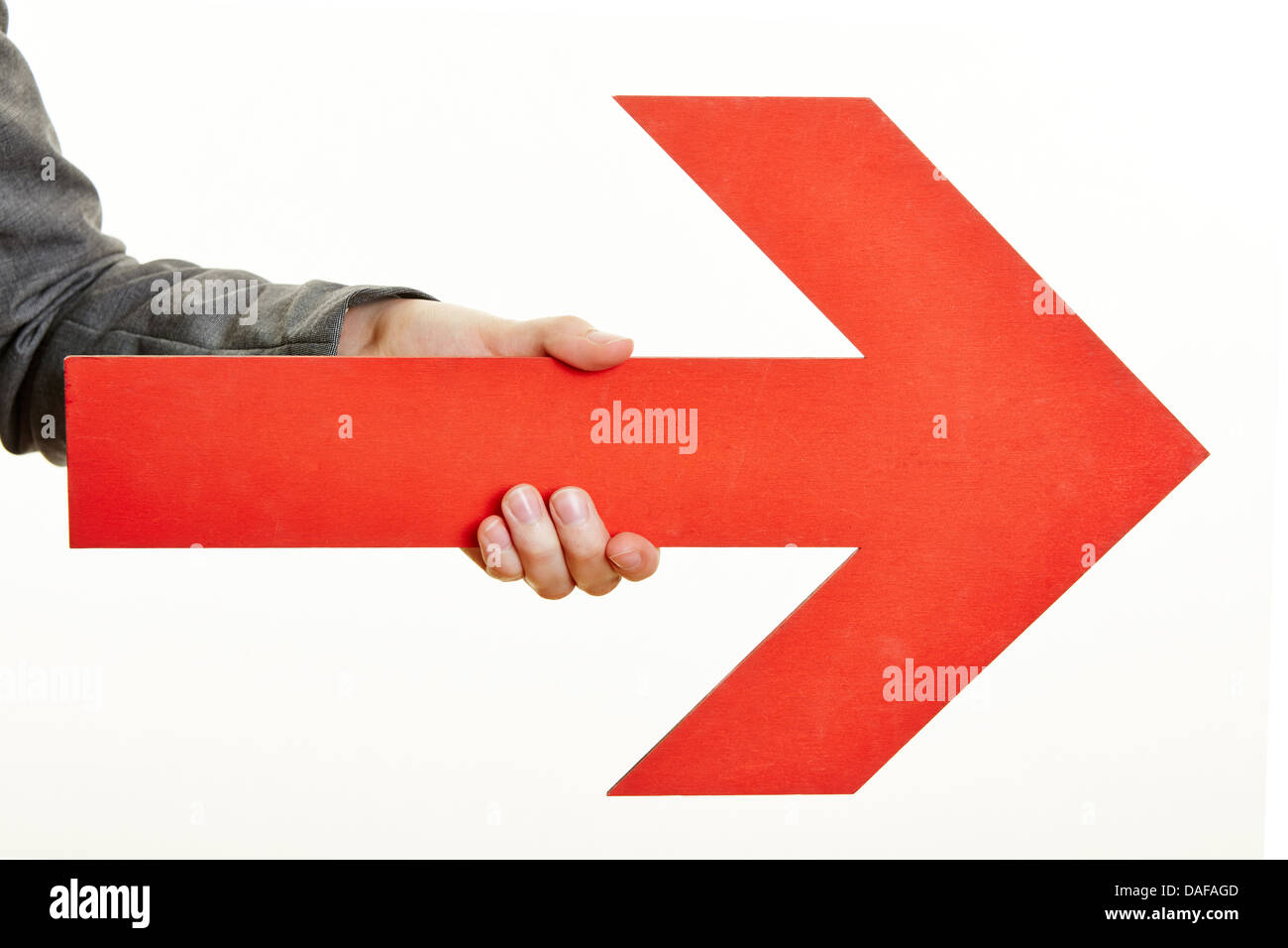 Hand holding a red arrow pointing to the right Stock Photo - Alamy