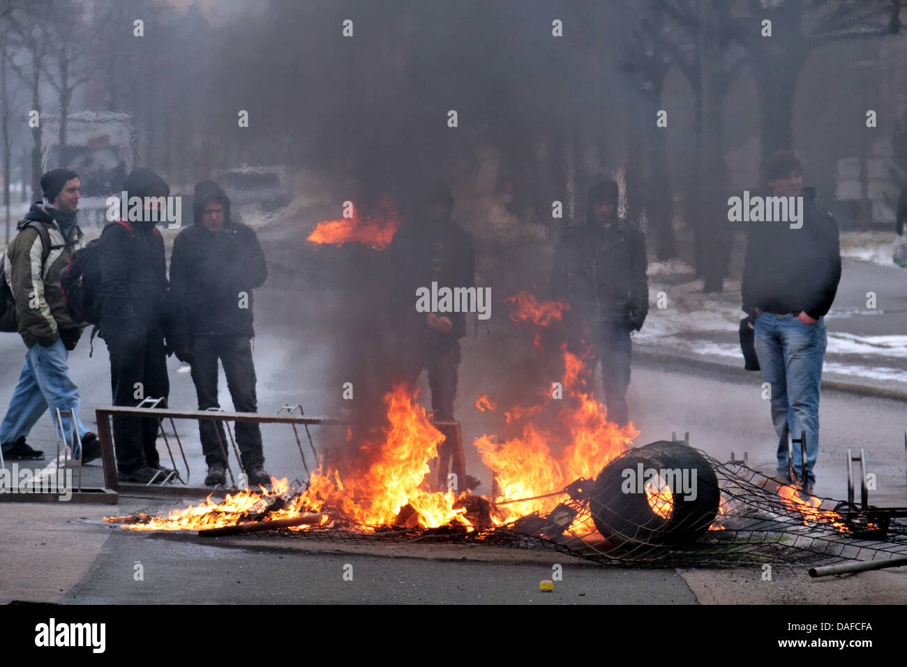 Pedestrians observe a burning barricade created by left wing protesters against a neo-Nazi demonstration in Dresden, Germany, 19 February 2011. About 4000 neo-Nazis from the whole of Europe and more than 20.000 counterprotesters from different places in Germany have gathered in Dresden; among them are approximatly 3000 members of the leftist autonomous scene. Photo: Jan Woitas Stock Photo