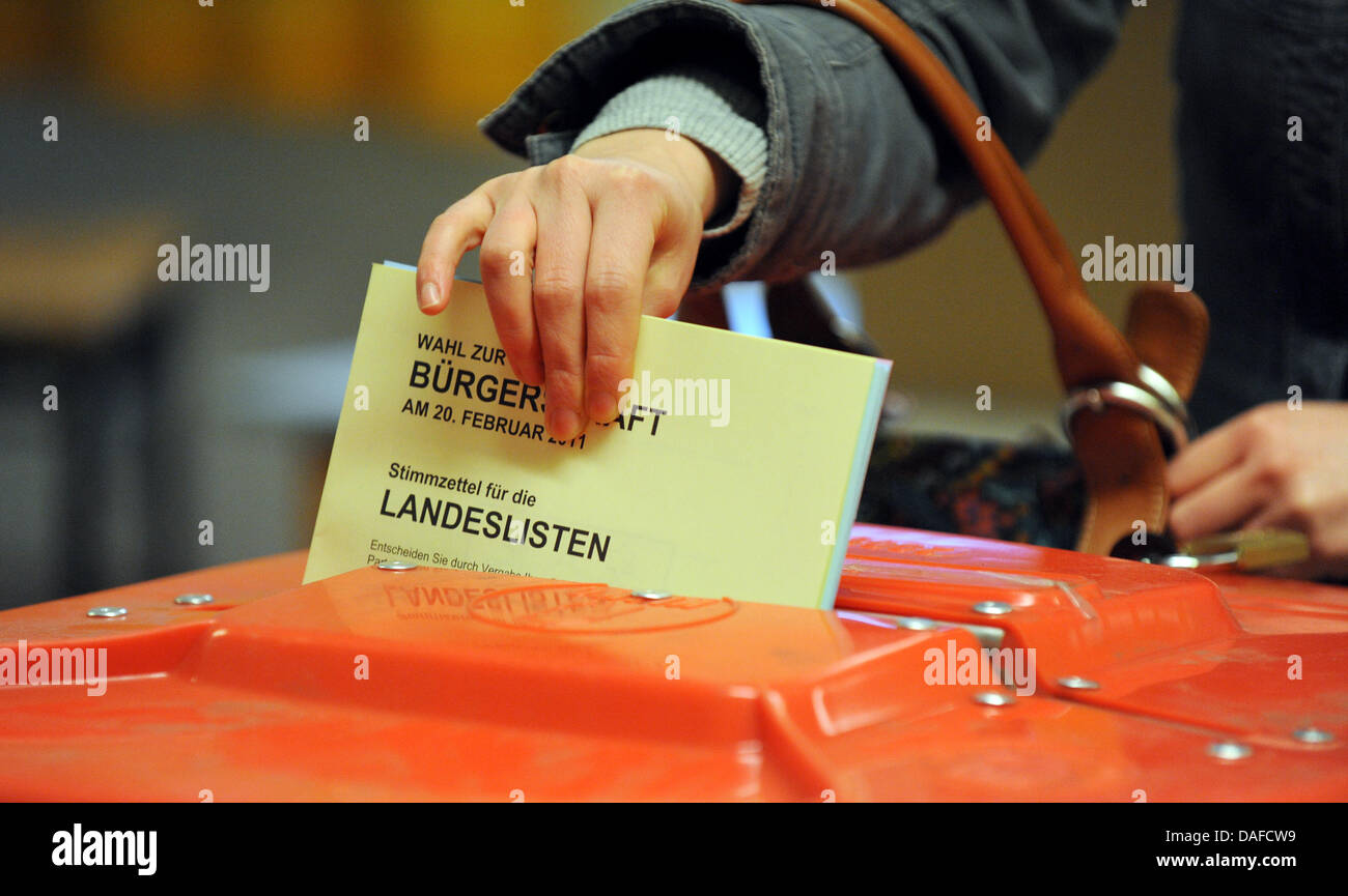 One of the first voters hands in her ballot for the Hamburg parliamentary elections at a voting station in Hamburg, Germany 20 February 2011. Around 1.3 million voters in Hamburg will elect representatives to the 121 seats in the Hamburg state parliament. Photo: Marcus Brandt Stock Photo