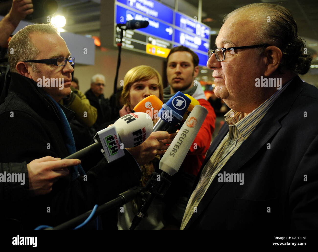 Attorney Peter Stompfe (R) from Marburg talks to journalists on his arrival from Tripoli, Libya, at the airport in Frankfurt, Germany, 21 February 2011. Stompfe has been frequently travelling to Libya for the past 16 years. Due to the escalating violence in Libya, German nationals were prompted to leave the country. A Lufthansa airplane landed this evening in Frankfurt from Tripoli Stock Photo
