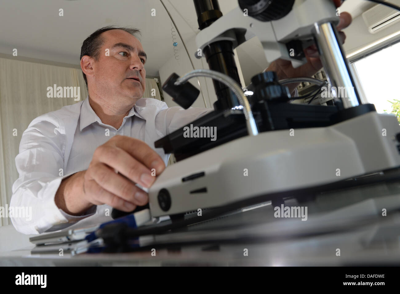 Electronic engineer Stephan Sauter, owner of Nano-Jewellery, adjusts his microscope in Lindau, Germany, 28 May 2013. Photo: FELIX KAESTLE Stock Photo