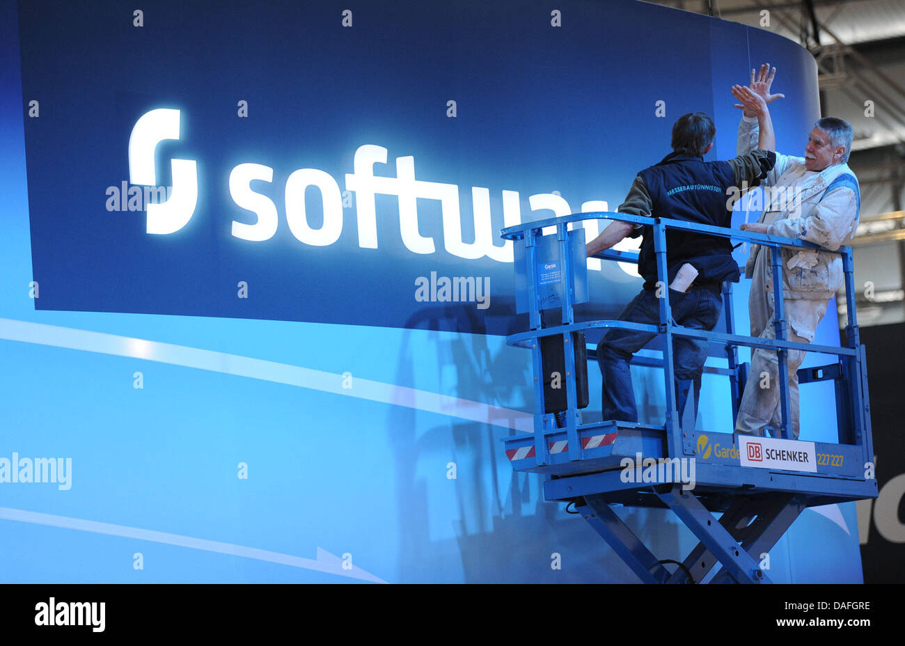 booth builders install a neon sign with the caption 'software' at the CEBIT on the trade show grounds in Hanover, Germany, 26 February 2011. The computer trade show CEBIT will take place from 1 to 5 March 2011 and over 200 companies from 70 countries will present novelties and innovations. Turkey is this year's partner country and German Chancellor Angela Merkel will inaugurate CEB Stock Photo