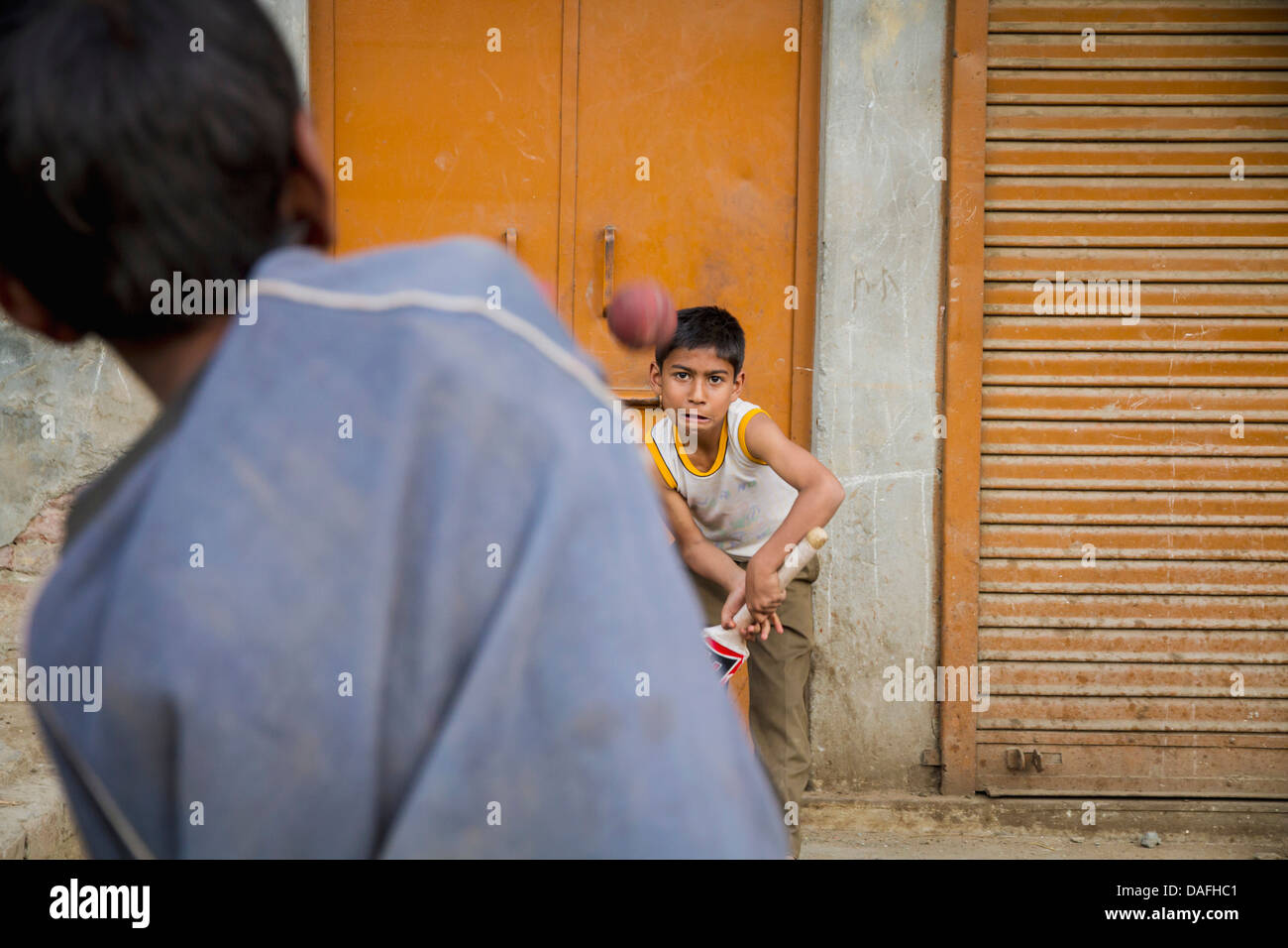 India, Amritsar, Boys playing cricket in city streets Stock Photo