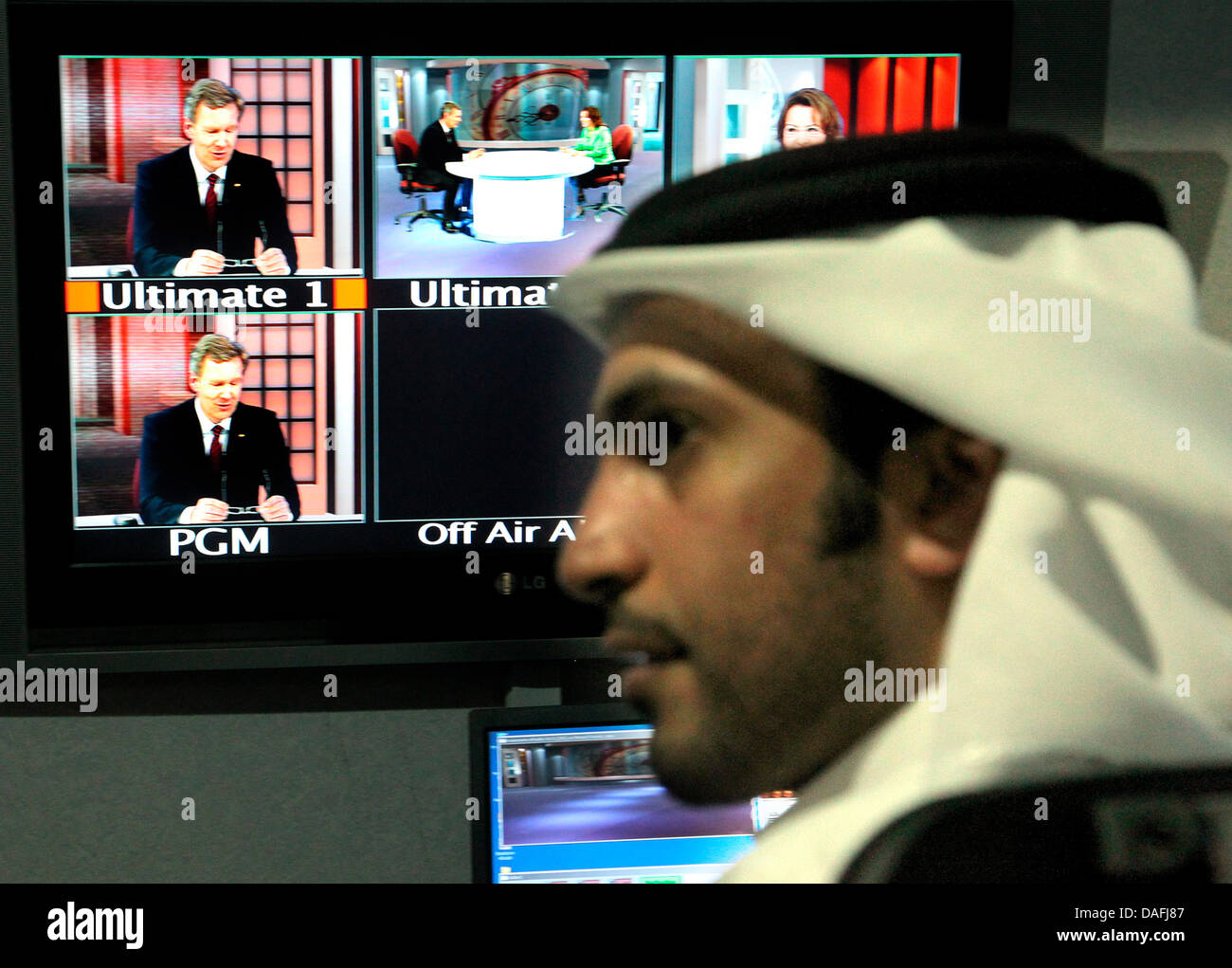 Bundespräsident Christian Wulff besucht am Montag (28.02.2011) in Doha in Katar den arabischen Fernsehsender Al Dschasira und gibt ein Fernsehinterview, wobei er auf einem Bildschirm zu sehen ist (l). Das deutsche Staatsoberhaupt hält sich zu einem dreitägigen Besuch in den Golfstaaten Kuwait und Katar auf. Foto: Wolfgang Kumm dpa Stock Photo