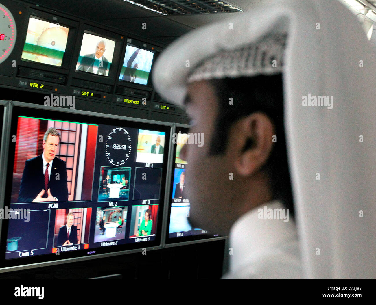 Bundespräsident Christian Wulff besucht am Montag (28.02.2011) in Doha in Katar den arabischen Fernsehsender Al Dschasira und gibt ein Fernsehinterview, wobei er auf einem Bildschirm zu sehen ist (l). Das deutsche Staatsoberhaupt hält sich zu einem dreitägigen Besuch in den Golfstaaten Kuwait und Katar auf. Foto: Wolfgang Kumm dpa Stock Photo