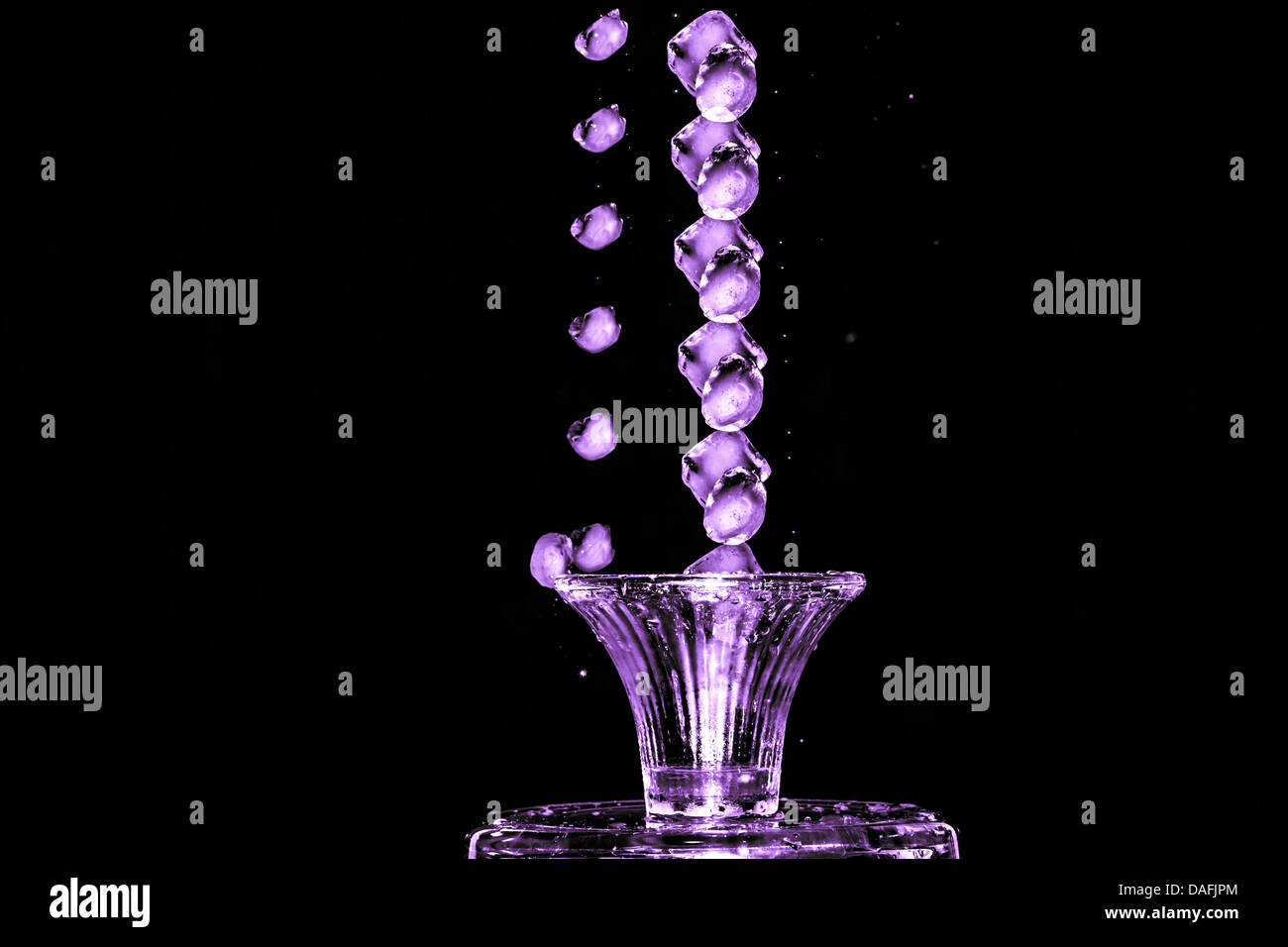Stroboscopic effect created using flash capturing the motion ice as it splashes into a glass Stock Photo