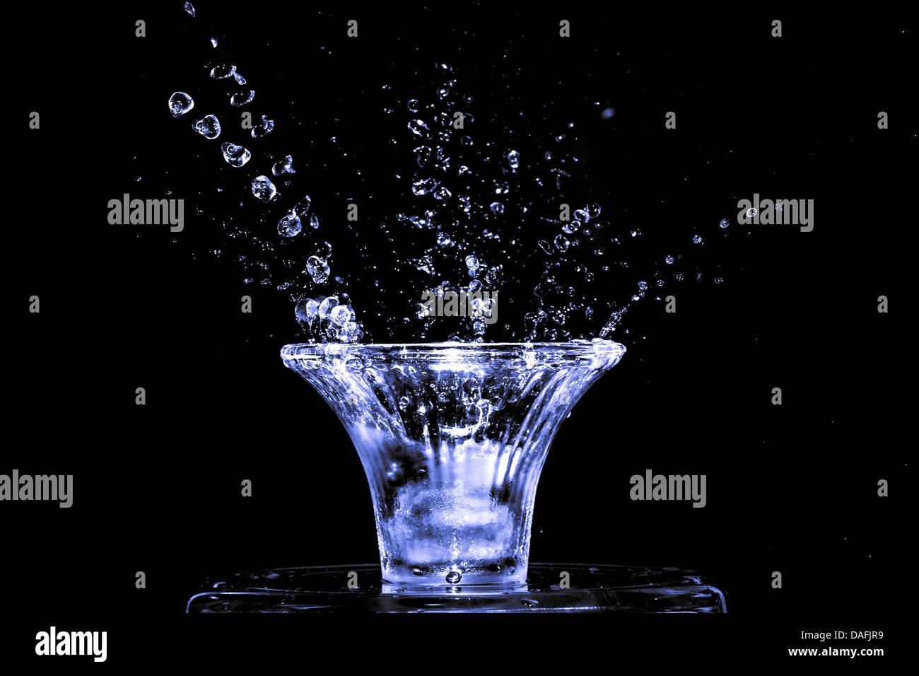 Stroboscopic effect created using flash capturing the motion ice as it splashes into a glass Stock Photo