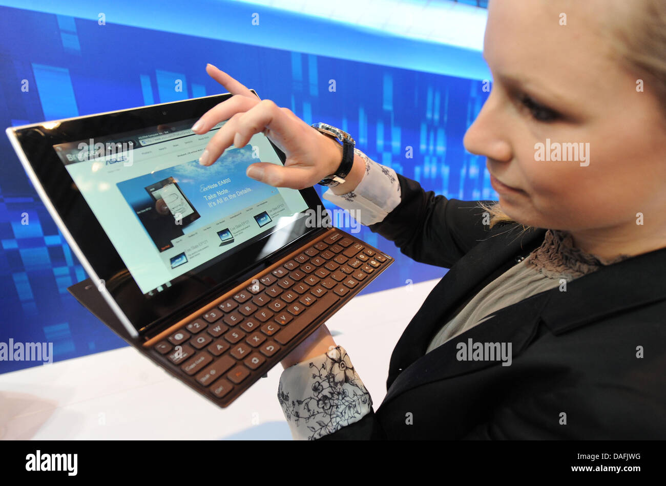 An employee of ASUS presents an ASUS Tablet Slice 10.1 inch computer with extensible keyboard during the construction of the CeBIT media showcase for computing technology on the tradeshow ground in Hanover, Germany, 28 February 2011. Cebit will present over 4200 companies from about 70 countries during the Cebit trade showcasing from 1 until 5 March 2011. this year's partner countr Stock Photo