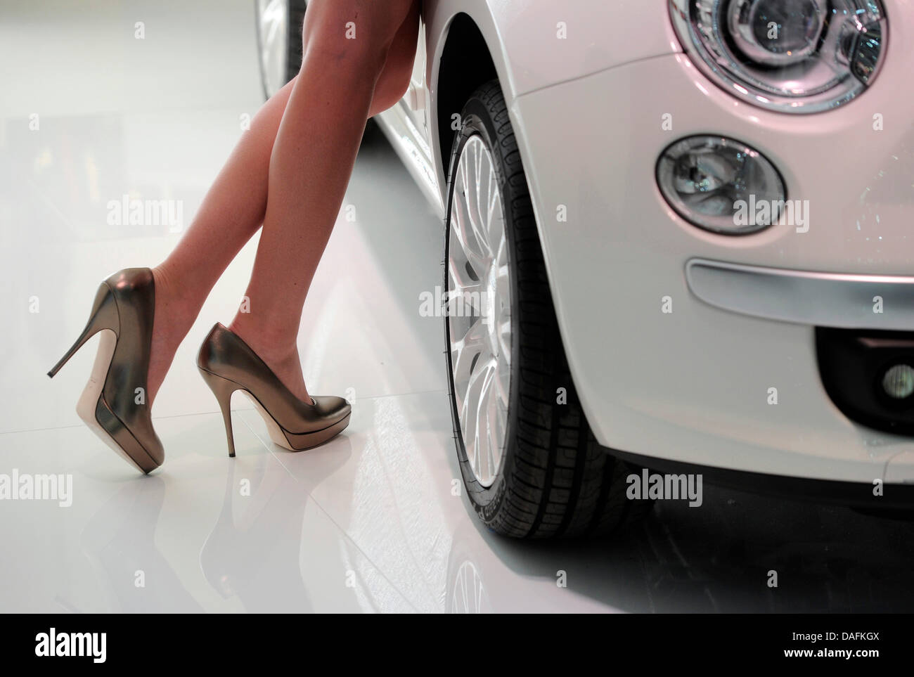 A model's feet in high heels are pictured next to a car on the second ...