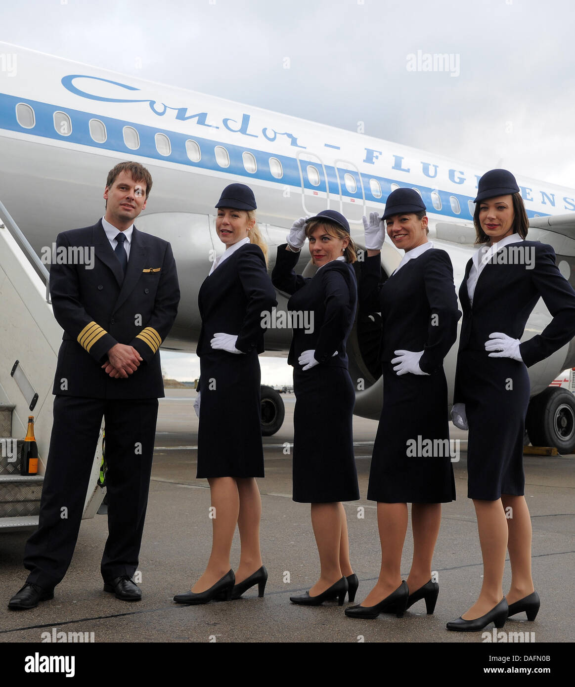 Captain Karl-Peter Ritter (L) and four flight attendants stand in front of a special retro-style Condor aircraft at the aiport in Schoenefeld, Germany, 05 December 2011. The airline calls the plane 'Hans' in honour of the founder of Geisler Tours that chartered the first Condor (Deutsche Flugdienst) aircraft in 1956. Photo: Bernd Settnik Stock Photo