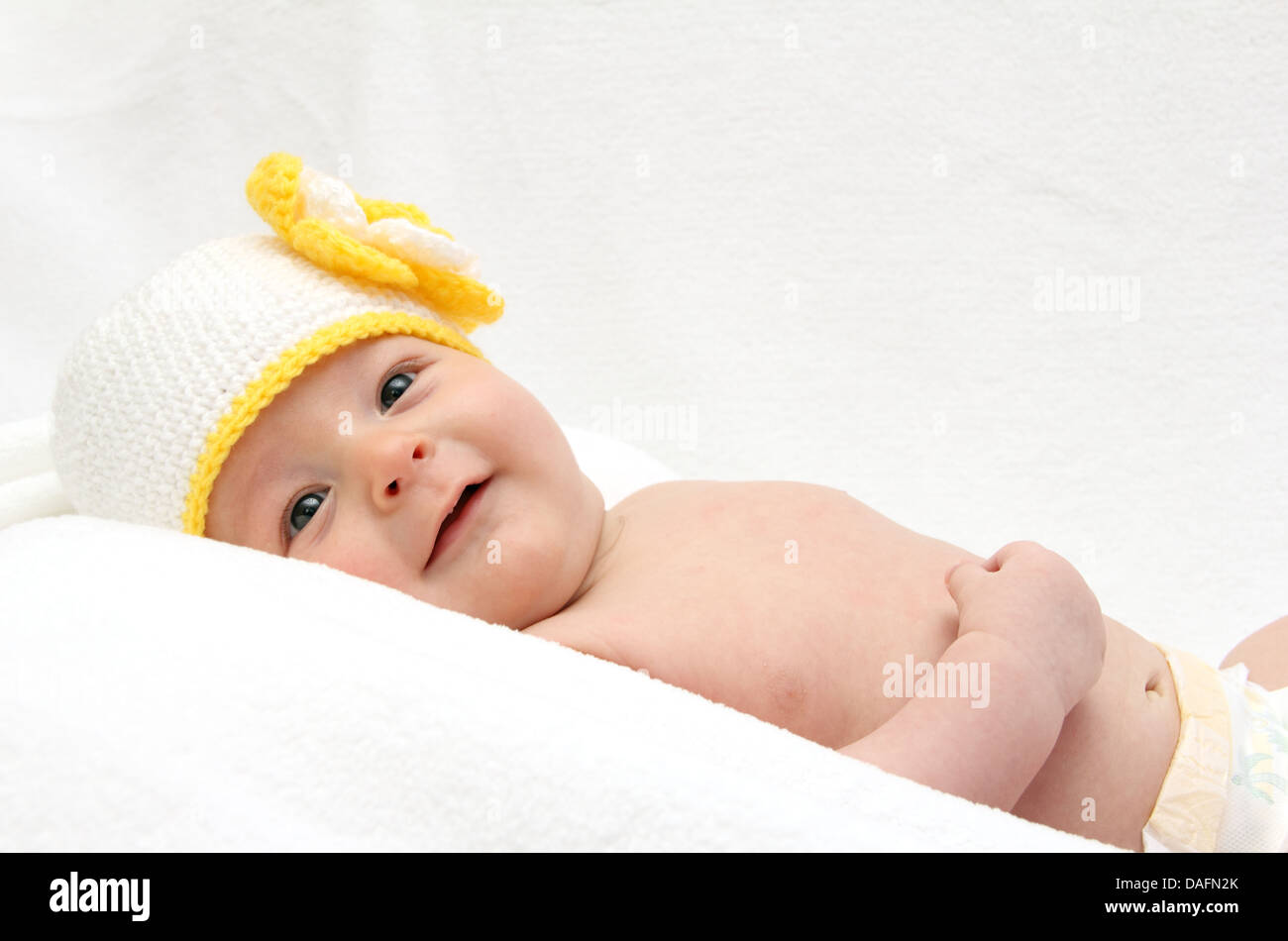 Baby with knitted white hat baby on back Stock Photo