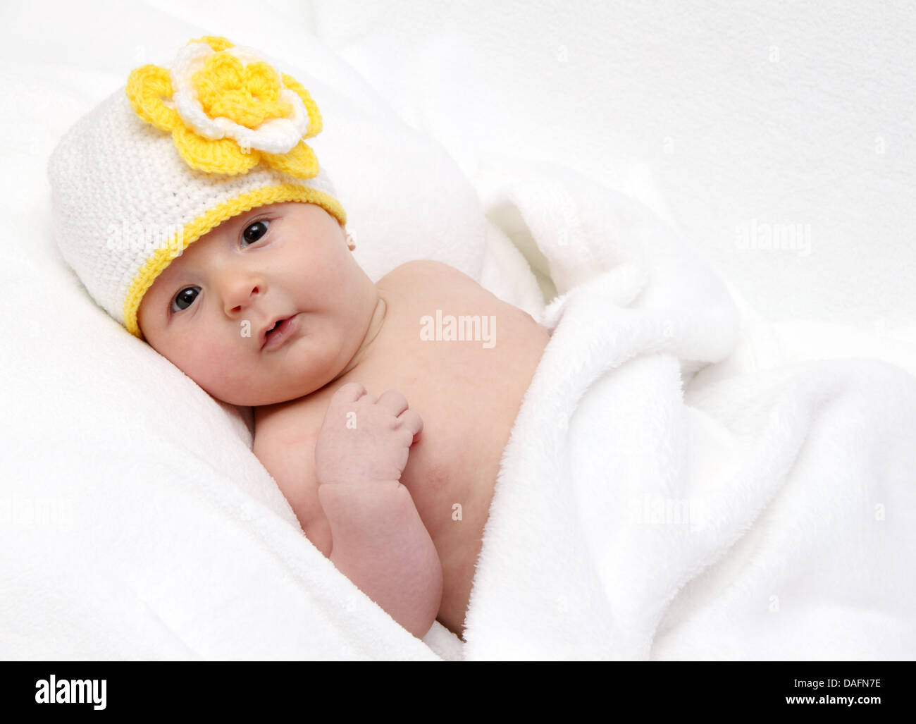 Baby with a knitted white hat baby on back Stock Photo